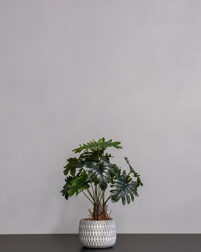 Närbild på detaljerna i Konstgjord Filodendron krukväxt med cementkruka – 32 cm